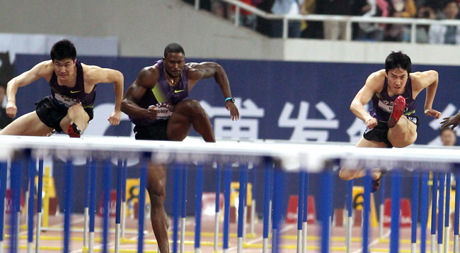 David Oliver (C) of the US competes with Liu Xiang (R) of China in the men&apos;s 110m Hurdles at the IAAF Diamond League athletics meet in Shanghai May 23, 2010.[China Daily/Agencies]