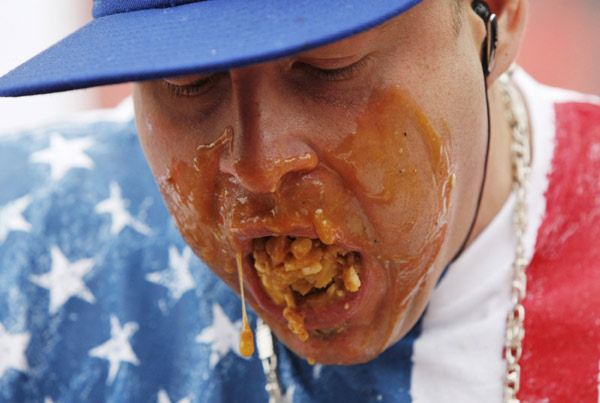 Pete &apos;Pretty Boy&apos; Davekos takes part in the &apos;World Poutine Eating Championship&apos; in Toronto, May 22, 2010. Contestants had 10 minutes to eat as much poutine, a dish consisting of french fries, cheese curds, and brown gravy, to win the championship. [Xinhua/Reuters]