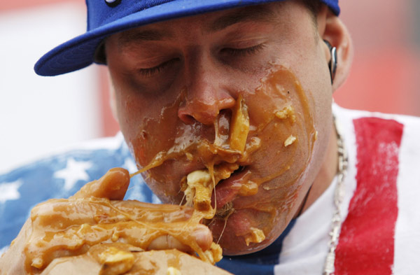 Pete &apos;Pretty Boy&apos; Davekos takes part in the &apos;World Poutine Eating Championship&apos; in Toronto, May 22, 2010. Contestants had 10 minutes to eat as much poutine, a dish consisting of french fries, cheese curds, and brown gravy, to win the championship. [Xinhua/Reuters]