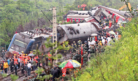 Carriages of a Shanghai-Guilin train are piled up near Dongxiang, Jiangxi province, after it derailed on Sunday morning because of a landslide. [China Daily/He Jianghua]