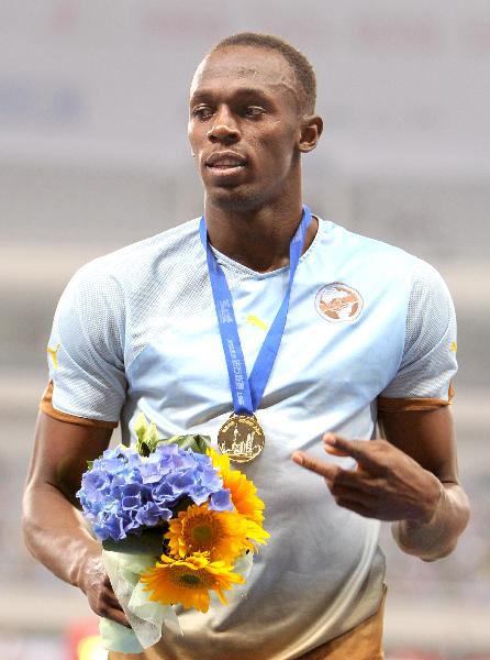 Usain Bolt of Jamaica poses on the awarding podium after winning the men's 200 metres race at the IAAF Diamond League athletic meeting in Shanghai, east China, May 23, 2010. Bolt won the champion with 19.76 seconds. (Xinhua/Fan Jun)