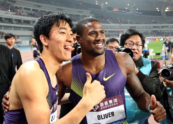 David Oliver (R) of the United States poses with Liu Xiang of China after the men&apos;s 110m hurdles at the IAAF Diamond League athletic meeting in Shanghai, east China, May 23, 2010. Oliver won the match with 12.99 seconds, and Liu ranked the third with 13.40 seconds.(Xinhua/Fan Jun)
