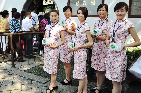  New tour guides, wearing Chinese traditional chi-paos, stand at the Zhuozhengyuan Garden of Suzhou, east China's Jiangsu Province, May 24, 2010. A total of 13 new tour guides, who would offer free explanations for tourists, began to work at the garden Monday. [Xinhua/Zhu Guigen] 