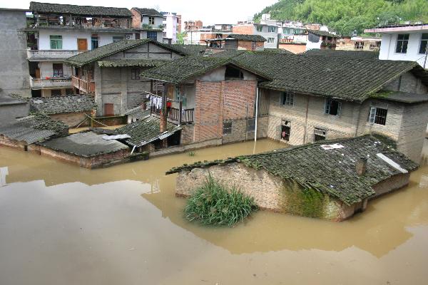 Houses are surrounded by flood in Shunchang County of Nanping City, southeast China's Fujian Province, May 23, 2010. Heavy rain hit the province on May 22 and 23. [Xinhua] 