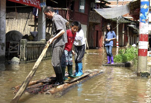 Residents take a raft for moving on a flooded street in Shunchang County of Nanping City, southeast China's Fujian Province, May 23, 2010. Heavy rain hit the province on May 22 and 23. [Xinhua] 