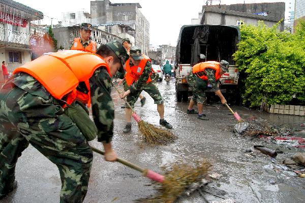 Soldiers clear a street in Xiamen, southeast China's Fujian Province, May 23, 2010. Heavy rain hit the province on May 22 and 23. [Xinhua] 