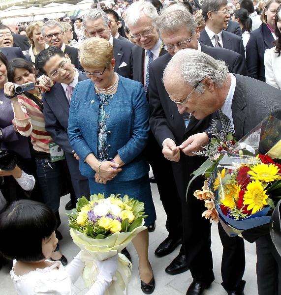 Swedish King Carl XVI Gustaf (R, front) receives flowers during his vitit to the Sweden Pavilion at the World Expo park in Shanghai, east China, May 23, 2010, the National Pavilion Day for Sweden. 
