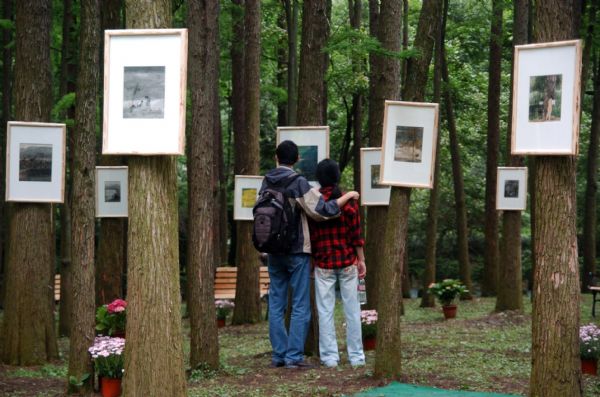 People view paintings of famous Chinese artist Zeng Mi's paintings at his personal exhibition held in the Hangzhou Botanic Garden in Hangzhou, capital of east China's Zhejiang Province, May 23, 2010. 