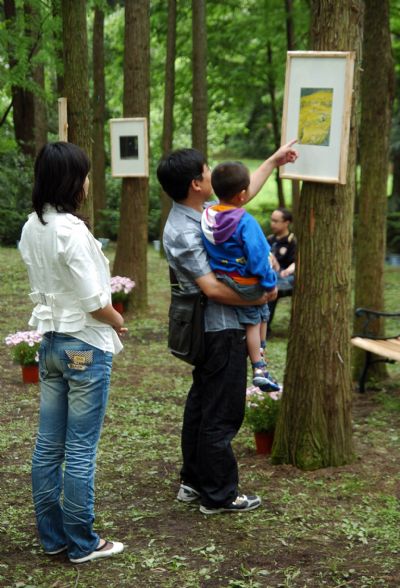 People view paintings of famous Chinese artist Zeng Mi's paintings at his personal exhibition held in the Hangzhou Botanic Garden in Hangzhou, capital of east China's Zhejiang Province, May 23, 2010. 