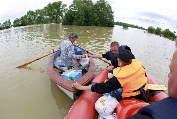  An emergency worker gives food suplies to a man on the boat at the flooded village of Juliszew close to Plock in Central Poland May 24, 2010. (Xinhua/Reuters Photo)