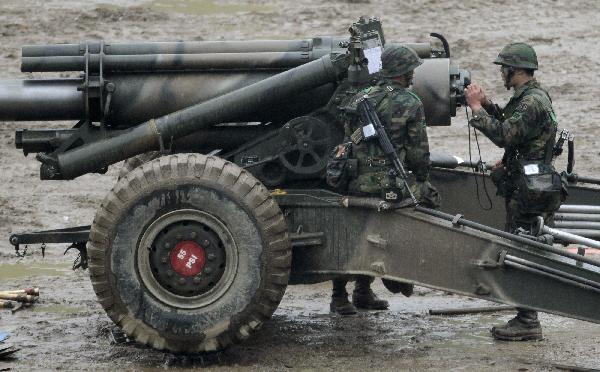 South Korean Army soldiers gather near a howitzer as they take part in a military drill at a firing range near the demilitarized zone separating the two Koreas in Paju, about 45 km (28 miles) north of Seoul, May 24, 2010. [Xinhua/Reuters]