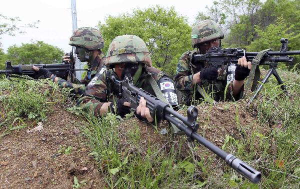 South Korean soldiers conduct a military drill near the demilitarized zone (DMZ) separating South Korea from North Korea in Yanggu, about 180 km (112 miles) northeast of Seoul, May 24, 2010 during a photo opportunity. [Xinhua/Reuters]
