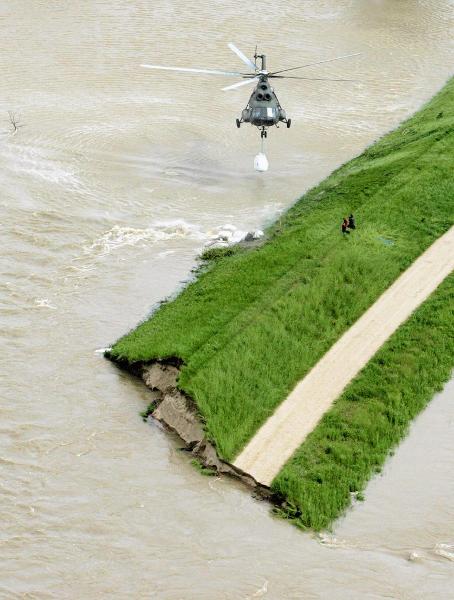 A helicopter drops sand bags to reinforce an already destroyed flood embankment near the village of Swiniary in Central Poland May 24, 2010. [Xinhua/Reuters]