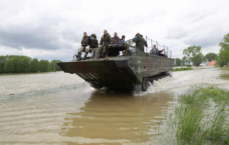 An amphibious vehicle transports people and farm animals from the flooded village of Juliszew close to Plock, central Poland May 24, 2010.[China Daily/Agencies]