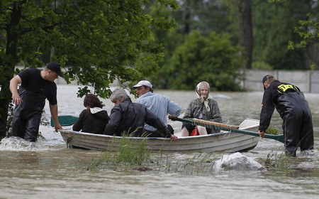 Emergency services rescue people from the flooded village of Juliszew May 24, 2010.[China Daily/Agencies]