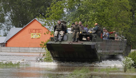 An amphibious vehicle transports people from the flooded village of Juliszew May 24, 2010.[China Daily/Agencies]