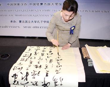 During the Chinese Book Fair held in Ulan Bator, Mongolia's capital, on May 24, Liu Liying from the Mongolian National University of Education of China performances Chinese calligraphy. [Xinhua photo]