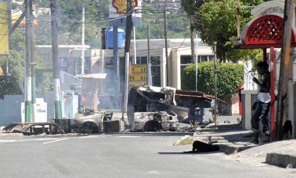 A resident stands by a road block the day after a state of emergency was called in Kingston, Jamaica, May 24, 2010. [Xinhua/Reuters]