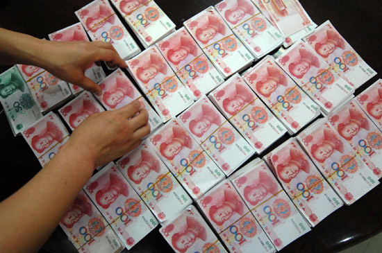 A policeman shows the counterfeit bills seized in an RMB counterfeit case in Xi'an, Shaanxi province, on May 25, 2010.