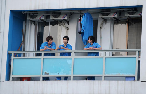 Xu (middle) talks with his colleagues on the balcony of their dorm in Hangzhou, East China's Zhejiang province, May 25, 2010.