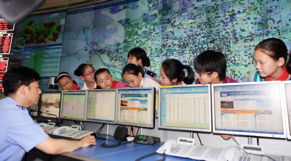 Pupils of Dongjiaominxiang Primary School visit the alarm information desk of Beijing '110' police commanding center during a thematic activity in Beijing, capital of China, May 25, 2010. Policeman of the '110' commanding center communicated with students and explained safety knowledge to them during the activity on Tuesday. 