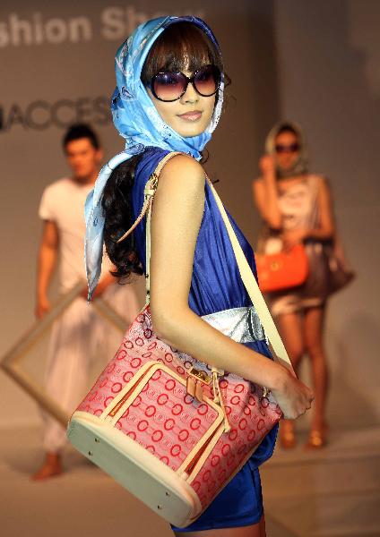 A model presents the new style of bag during a show at the National Convention Center in Beijing, capital of China, May 25, 2010. A bag and luggage show of Taiwan brands was held on Tuesday during the 3-day Beijing top shoes and fashion accessories exhibition. 