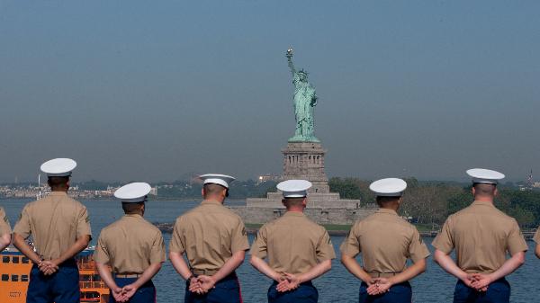 U.S. Navy and Marine Corps personnel stand at the rails of the USS Iwo Jima as the amphibious assault ship passes the Statue of Liberty while entering the New York Harbor for Fleet Week in New York, the United States, May 26, 2010. The 23rd annual New York Fleet Week kicked off on the Hudson River Wednesday morning. [Xinhua] 