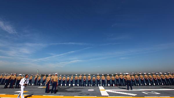 U.S. Navy and Marine Corps personnel stand at the rails of the USS Iwo Jima as the amphibious assault ship passes the Statue of Liberty while entering the New York Harbor for Fleet Week in New York, the United States, May 26, 2010. The 23rd annual New York Fleet Week kicked off on the Hudson River Wednesday morning. [Xinhua]