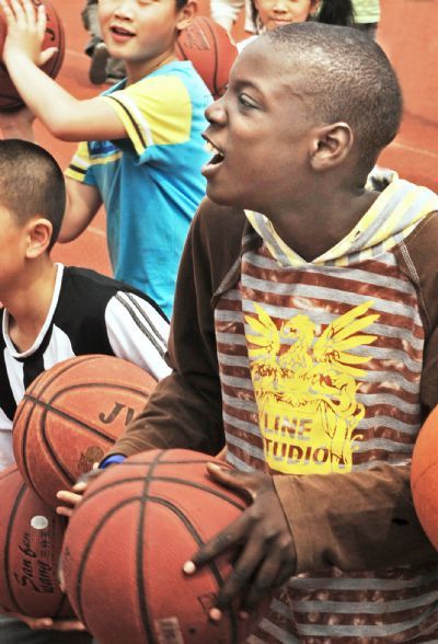 Muhammed plays basketball at school, in Yiwu, east China&apos;s Zhejiang Province, May 26, 2010. Muhammed, 11 years old, and his sister Kichh, 8 years old, came to Yiwu 5 years ago with their parents who run businesses here. They entered a local school successively in 2007 and 2008, and they are very fond of Chinese culture. [Xinhua] 