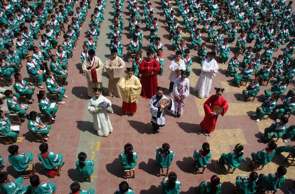 Photo taken on May 25, 2010 shows children wearing ancient costumes of Han ethnic group at the Yifu Primary School in Zaozhuang, east China's Shandong Province. The primary school invited professionals to introduce the culture of ancient costumes of Han ethnic group to students on Tuesday. (Xinhua/Sun Zhongzhe) 