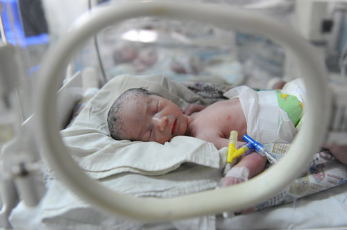 A baby girl rests inside an incubator shortly after being born to a 60-year-old mother at a hospital in Hefei city, capital of East China's Anhui province, on Tuesday, May 25, 2010.