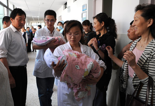 Two baby girls are carried out of the delivery room shortly after their births by a 60-year-old woman at a hospital in Hefei city, capital of East China's Anhui province, on Tuesday, May 25, 2010. 