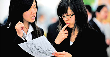A university student (right) consults a company manager at a job fair in Shenyang, capital of Liaoning province, in this file photo.[Zhang Wenkui/Xinhua] 