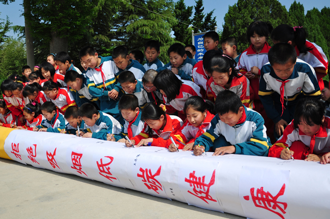 Students of Wuji School write slogans to call upon people to quit smoking at Wuji School in Rushan City, east China&apos;s Shandong Province, May 27, 2010. With the coming of the World No-Tobacco Day on May 31, students in Zaozhuang City launched a no-tobacco compaign recently to advocate the life style of no tobacco and low-carbon health. [Xinhua] 
