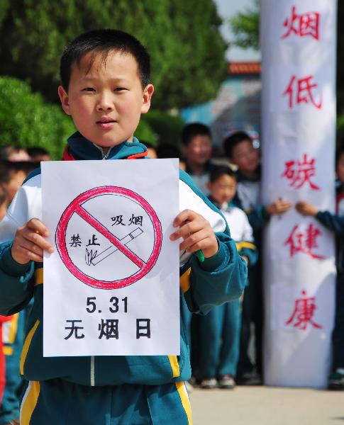 A student of Wuji School shows the sign of no smoking drawn by himself to call upon people to quit smoking and live healthily, in Rushan City, east China&apos;s Shandong Province, May 27, 2010. With the coming of the World No-Tobacco Day on May 31, students in Rushan City launched a no-tobacco compaign recently to advocate the life style of no tobacco and low-carbon health. [Xinhua]