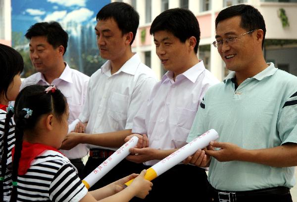 Pupils give cigarette models to their parents who smoke to persuade them to quit smoking, at Hongqi Primary School in Zaozhuang City, east China&apos;s Shandong Province, May 27, 2010. With the coming of the World No-Tobacco Day on May 31, students in Zaozhuang City launched a no-tobacco compaign recently to advocate the life style of no tobacco and low-carbon health. [Xinhua]