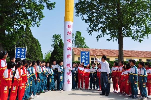 Teacher of Wuji School teaches students the harm of smoking, in Rushan City, east China&apos;s Shandong Province, May 27, 2010. With the coming of the World No-Tobacco Day on May 31, students in Rushan City launched a no-tobacco compaign recently to advocate the life style of no tobacco and low-carbon health. [Xinhua]