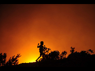 A child runs back home as the sun sets at Liujing village, Liujing township of Heng county of in the South China's Guangxi Zhuang autonomous region on May 21, 2010. [Xinhua]