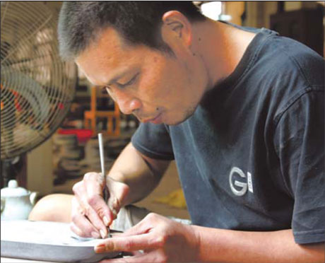 A craftsman works on a Duan inkstone.