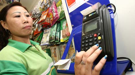 An employee in a convenience store in Suzhou, Jiangsu province, demonstrates how to use a Lakala terminal.