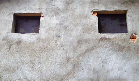 The low-lying, gray cement building with small windows sealed by iron plates was used to keep the two girls.