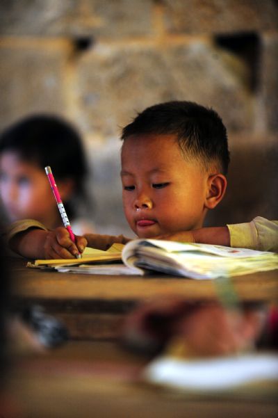 Luo Jiangping, 4 years old, does his homework in the classroom in Naliang Village of Qiangxu Township, Dahua Yao Autonomous County of southwest China's Guangxi Zhuang Autonomous Region, May 17, 2010. 