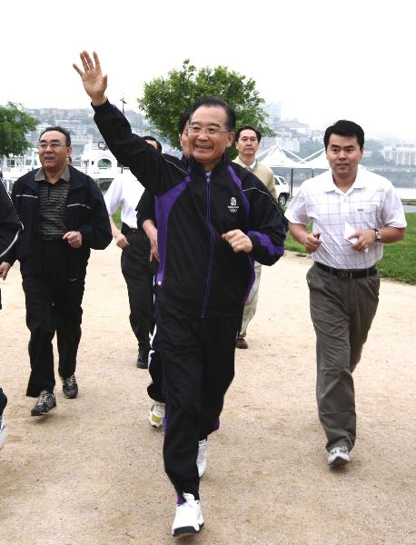 Chinese Premier Wen Jiabao waves to local residents as he joins them in morning exercises in Seoul, May 29, 2010. Seeking to increase cooperation and good neighborliness with South Korea, Chinese Premier Wen Jiabao on Friday started his three-day official visit to the country. [Yao Dawei/Xinhua]