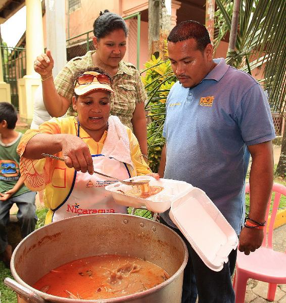 A man and others wait for food at the food festival in Bluefields, Nicaragua, May 28, 2010. A food festival were held in Bluefields which locates in east of Nicaragua and is also a popular tourist destination. The food festival features traditional Caribbean food and local Tululu dances. [Xinhua]