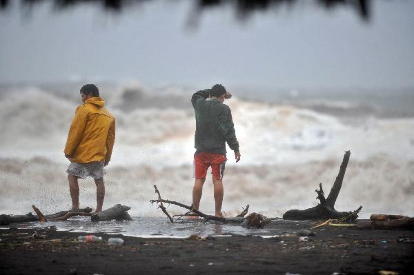 Two men watch heavy swell on May 29, 2010, in San Jose port, Escuintla, south of Guatemala City. The season's first tropical storm Agatha has killed 73 people in Guatemala, as drenching rain, mudslides and floods forced 3,000 to flee their homes, officials said. (Xinhua/AFP