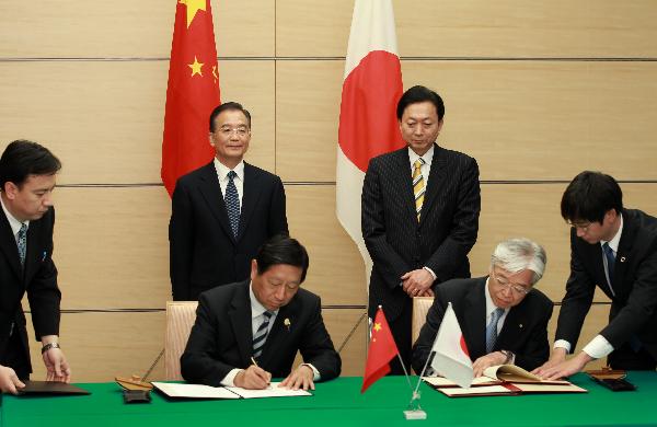 Chinese Premier Wen Jiabao (L, rear) and Japanese Prime Minister Yukio Hatoyama (R, rear) attend a signing ceremony after they held talks, in Tokyo, capital of Japan, May 31, 2010. [Xinhua]