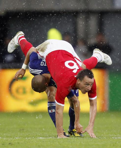 England's John Terry (R) falls over Japan's Daiki Iwamasa during their international friendly soccer match in Graz, May 30, 2010. (Xinhua/Reuters Photo) 