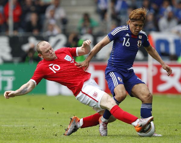 England's Wayne Rooney (L) tackles Japan's Yoshito Okubo during their international friendly soccer match in Graz, May 30, 2010.(Xinhua/Reuters Photo)