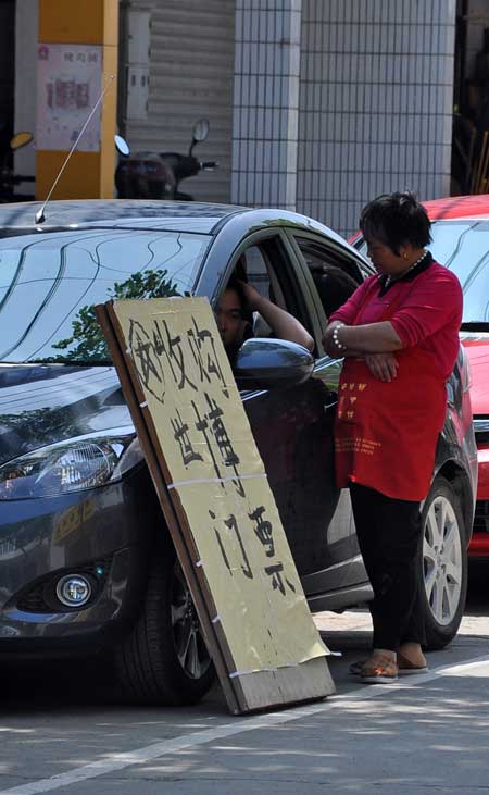 An advert offering to pay for unwanted Expo tickets leans against a car on Chongming Island Sunday. Photo by Cai Xianmin