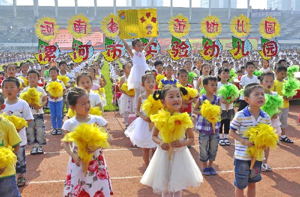 A phalanx of children from the Luohe City's Experimental Kindergarten take part in a collective loud elocnte of traditional Chinese classical literature, to mark the forthcoming June 1st International Childrens' Day, at the hometown of Xu Shen, a pioneering ancient Chinese dictionary compilor dated back to the Eastern Han Dynasty (25-220), at the Stadium of Luohe City, central China's Henan Province, May 30, 2010.